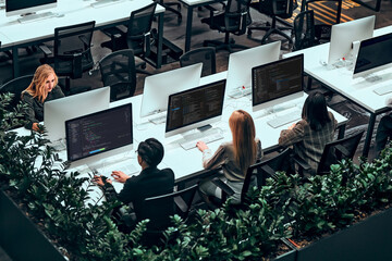 Photo from above. Business people work on computers in a spacious office center. Data analysis,...