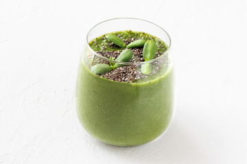 Raw green smoothie with microgreens alfalfa sprouts and chia seeds in a glass on white background.