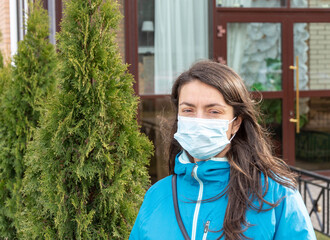 A young pretty white woman is wearing a protective medical face mask due to air pollution or a...