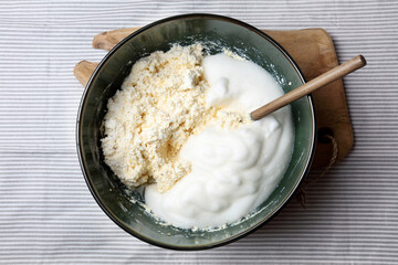 Homemade casserole mix: cottage cheese and beaten egg whites in a ceramic bowl