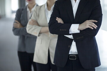 Business people standing with arms folded in office