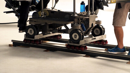 Dolly track setting up by film crew man. Behind the scene of video production crew setting dolly...