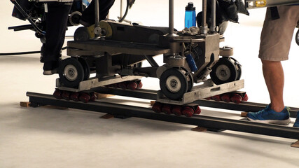 Dolly track for Video Production. Crew setting dolly track in studio. Professional dolly equipment for filming the movie. 