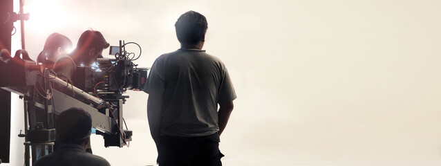 Behind the scenes of video production shooting. Professional camera and film crew team in studio....
