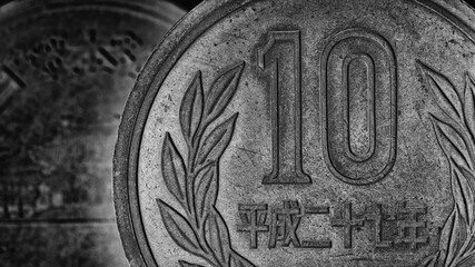 Translation: Japan 2015. Japanese coins of 10 yen close-up. Dark gray dramatic website background. Wallpaper or backdrop about money, economy, finance, taxes and financial management. Macro