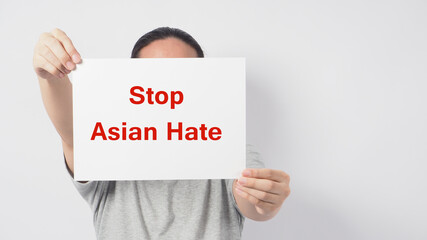 Stop asian hate in red color write in white board paper.Asian man holding paper on white background.