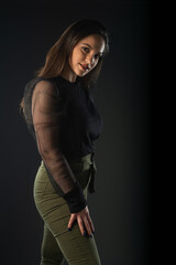 Portrait of beautiful model in black dress, hat and sunglasses on gray background