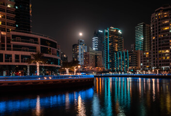 Dubai Marina District in Dubai. High buildings is reflecting in the water in the night illumination. Dubai, UAE. 