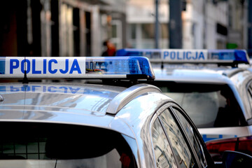 Policyjne radiowozy zaparkowane na ulicy w mieście.  © FotoDax