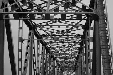 metal structure of a road bridge against a gray sky