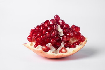 Broken ripe pomegranate fruit on a white background. juicy pomegranate berries. background.