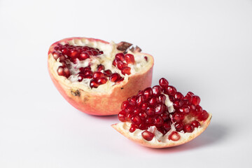 Broken ripe pomegranate fruit on a white background. juicy pomegranate berries. background.