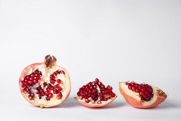 Broken ripe pomegranate fruit on a white background. juicy pomegranate berries. background.