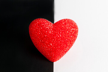 Fototapeta premium Red heart on black and white background. The heart is in the middle.
