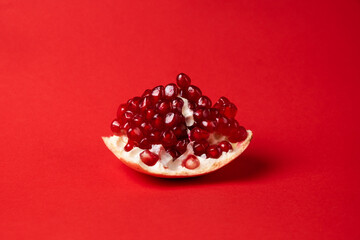 Broken ripe pomegranate fruit on a red background. juicy pomegranate berries. background.