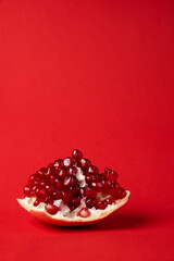 Broken ripe pomegranate fruit on a red background. juicy pomegranate berries. background.
