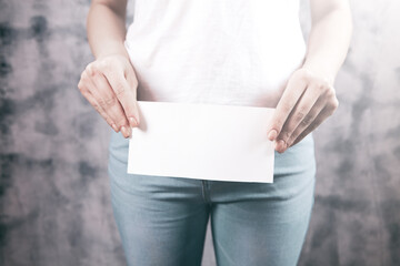girl holding a blank sheet of paper in her hands