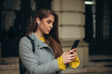 Woman using a smartphone while walking in the city while outside