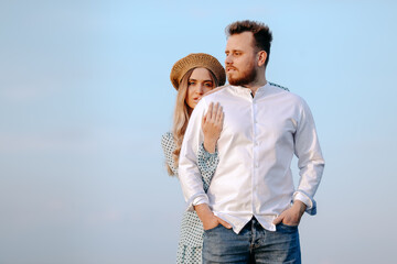 A handsome man in front of a lovely woman  on blue sky background