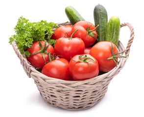 Basket with vegetables. Tomatoes, cucumbers and parsley in a basket. Isolate on white background 