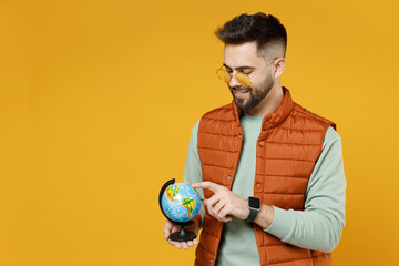 Young smiling happy geography student teacher fun caucasian man 20s wearing orange vest mint...