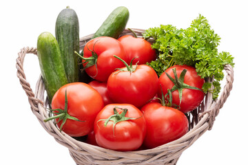 Basket with vegetables. Tomatoes, cucumbers and parsley in a basket. Isolate on white background 