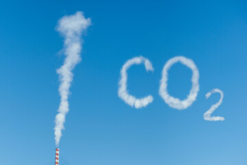 White-gray smoke is polluting from chimney in blue sky in sunny day. Environmental pollution carbon...