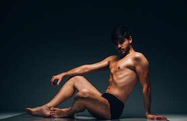 Portrait of an Caucasian male fashion model posing in black underwear