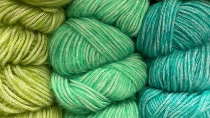 Green-azure range of wool yarn. Multicolored skeins of wool close-up