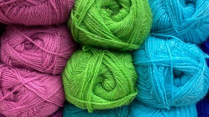 Blue, green and pink of wool yarn. Multicolored skeins of wool close-up