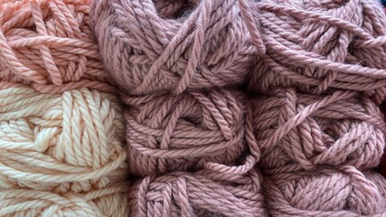 pink and white range of wool yarn. Multicolored skeins of wool close-up