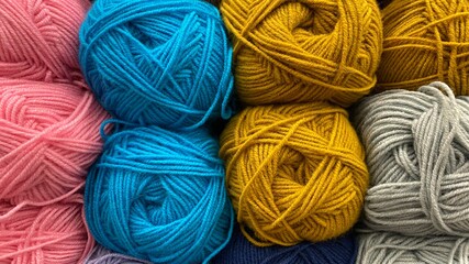 Blue, yellow and pink range of wool yarn. Multicolored skeins of wool close-up