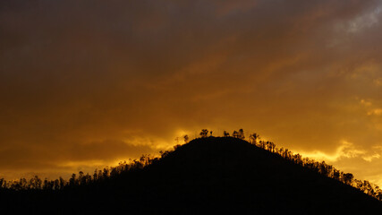 atardecer en montañas, cielo en llamas, arboles y sombras, paisaje 