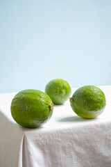 limes on white table and blue background