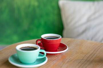 coffee in red and mint cups, on a wooden table. americano, espresso, cappuccino, black coffee start of the day