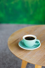 coffee in a mint-colored cup on a wooden table, start the day or lunch with partners in a coffee shop, meet with friends or coffee alone, enjoy the taste of black coffee Americano or cappuccino