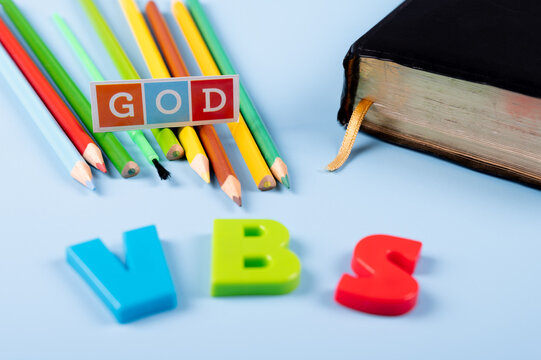 Church  background with Abbreviation "VBS" (Vacation Bible School) next to  black bible . Copy space text. Selective focus.