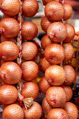 Onion bunches in open air market stall.