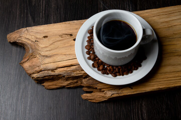Cup of coffee on a rustic wood. Coffee grains.