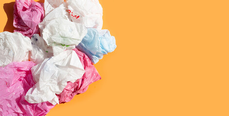 Colorful plastic bags on orange background.
