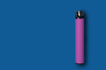 Disposable e-cigarette in purple color on blue isolated background. The concept of modern smoking, vaping and nicotine. Top view