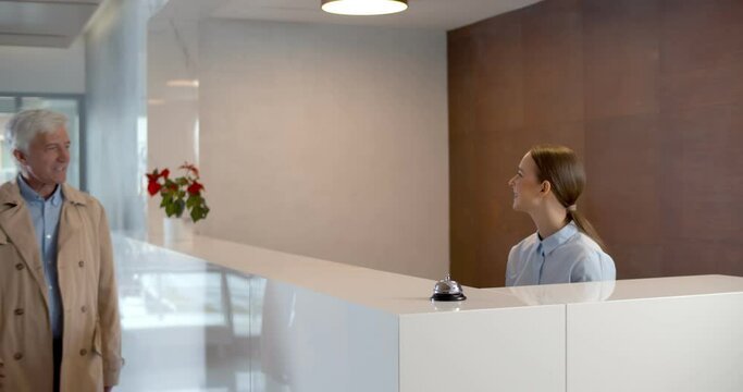 Hotel staff welcome visitor and giving room key after check in