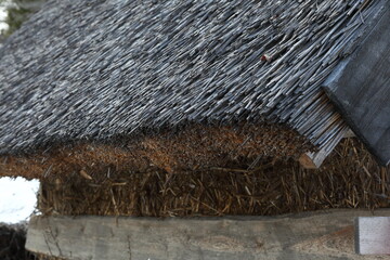 Shot of eaves of reed (thatch) roof after 3 years of construction. Water, snow and UV radiation only affect and penetrate the top layer of the roofing, about 5 cm. 