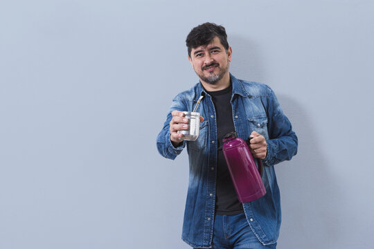 Persona ofreciendo mate cebado con termo bord&oacute; en mate y bombilla de metal