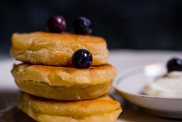small pancakes made of cheese and flour on a white beautiful plate with a blue background delicious food
