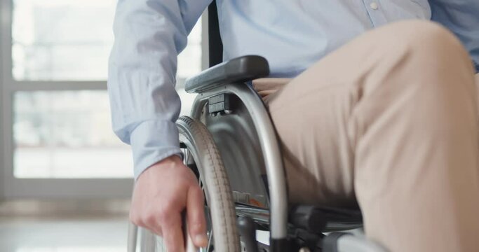 Close up of disabled man riding in wheelchair