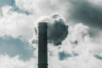 Environmental pollution, environmental problem, smoke from the chimney of a plant or thermal power plant against the sky