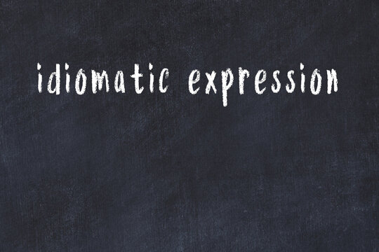 Black chalkboard with inscription idiomatic expression on in