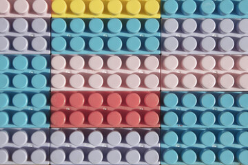 children's play background: the plane of plastic multi-colored bricks, blur, selective focus