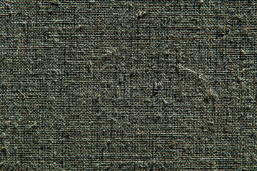 dark creative background: reverse side of black-primed linen canvas, uneven lighting, color toning